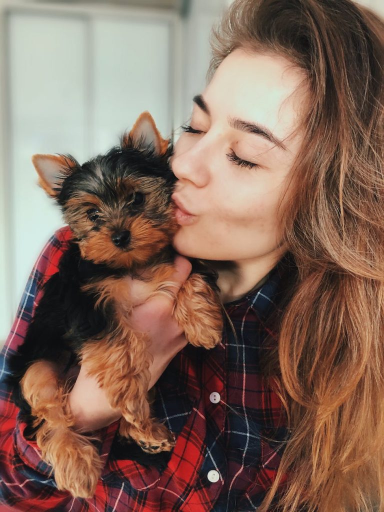 woman kissing yorkshire terrier